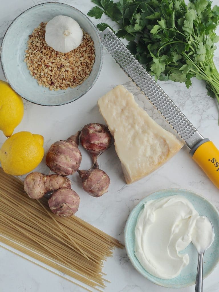 A simple vegetarian spaghetti dish with sautéed Jerusalem artichokes, Spaghetti, hazelnut parsley pesto, and lots of grated Parmesan | Natural Kitchen Adventures 